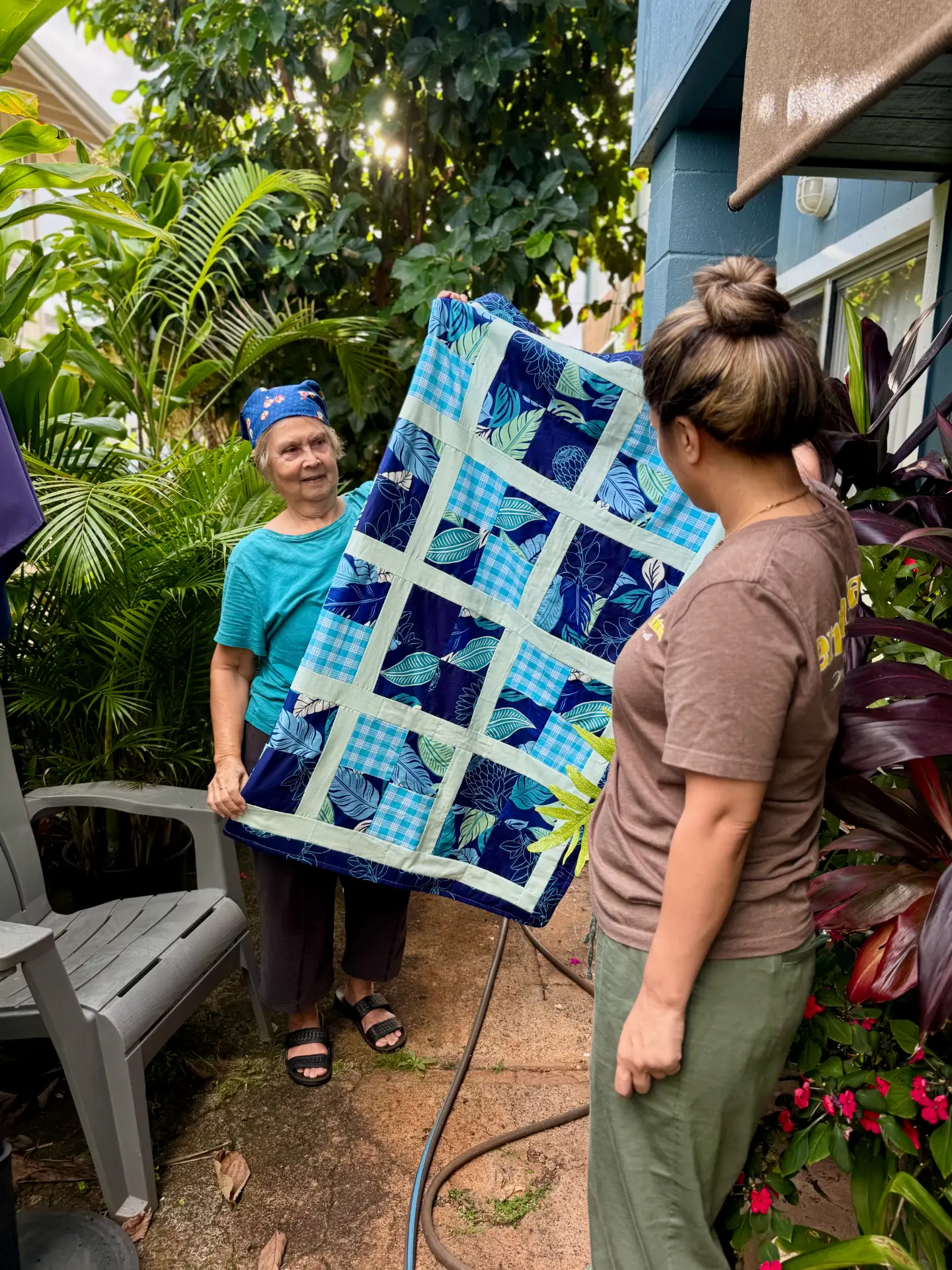 Tutu Lu holding up a finished blue Hawaiian patchwork blanket